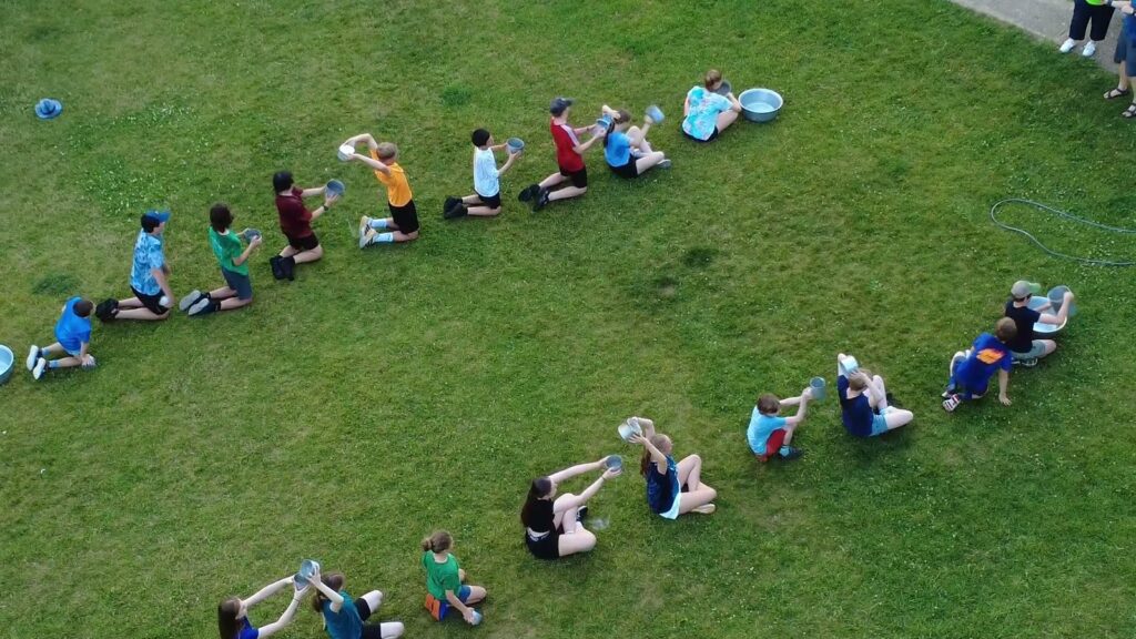 Scouts playing the water relay game on the field