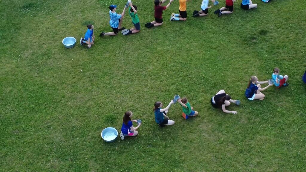 Scouts playing the water relay game on the field