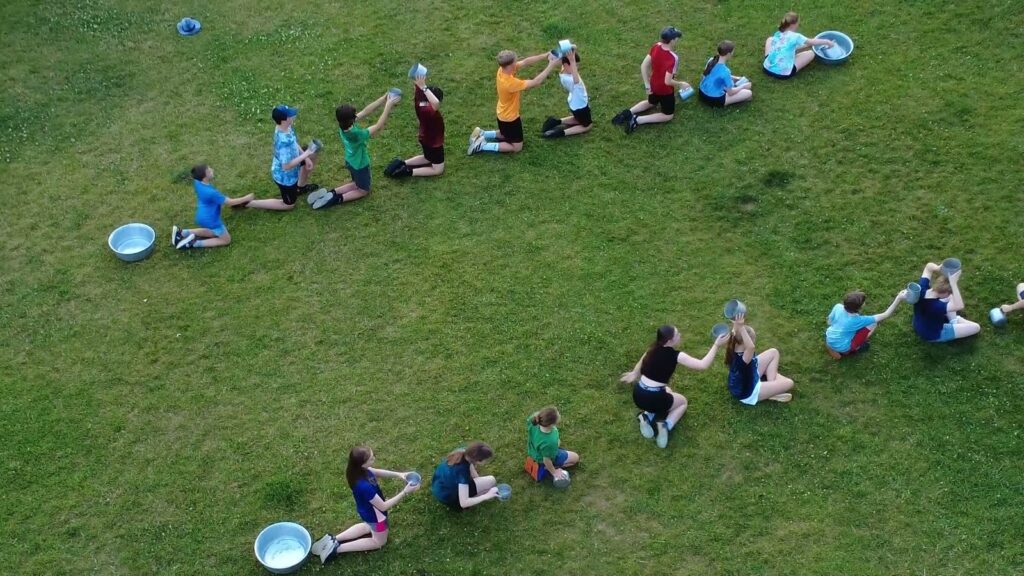 Scouts playing the water relay game on the field